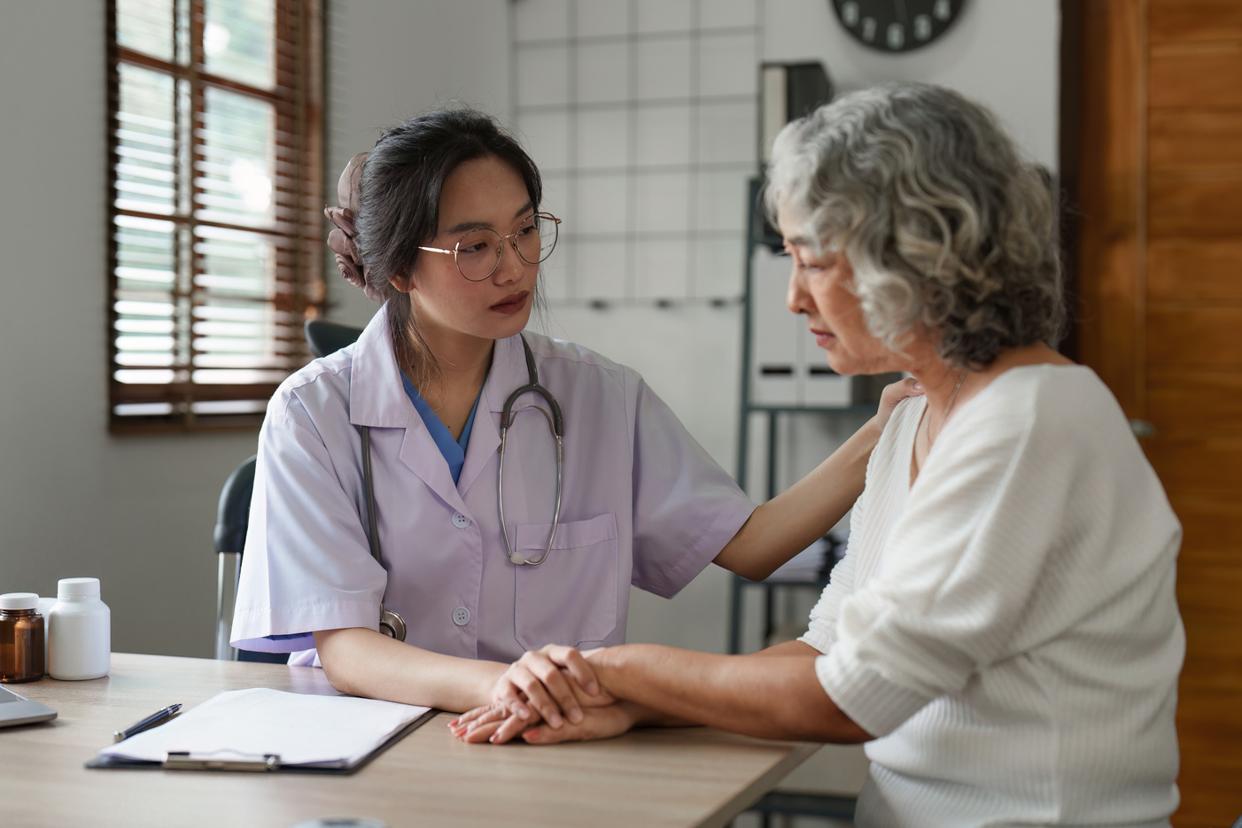 Doctor talking with elderly asian woman. Female primary care physician having conversation with older woman. Elderly Healthcare